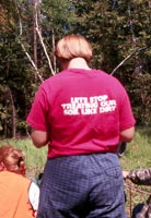 Forest Service crew members at a forest site - one with t-shirt reading don't treat our soil like dirt